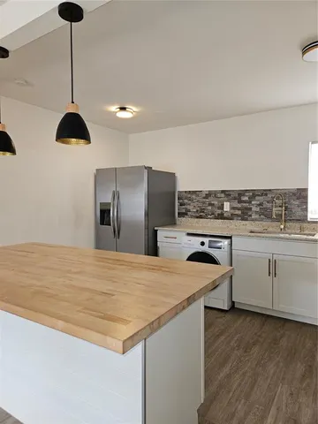 a kitchen with stainless steel appliances granite countertop a sink a stove and a refrigerator