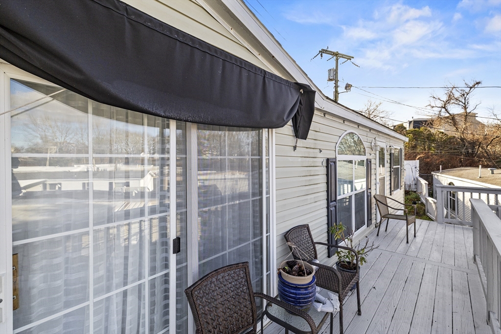 45 Kins Court Wareham, MA 02558 - Photo 5 of 16 a view of a balcony with chairs and wooden floor