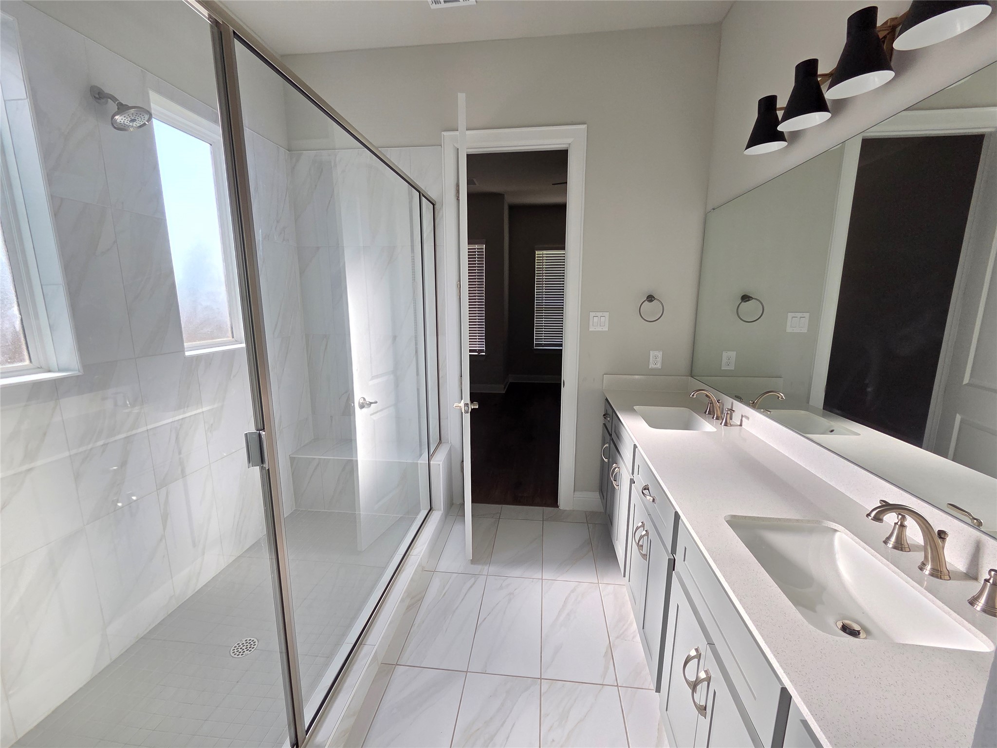 600 C-Bar Ranch Trail, Unit 121 Cedar Park, TX 78613 - Photo 19 of 32 Dual vanities and a spacious glass-enclosed shower create a modern and functional bathroom.