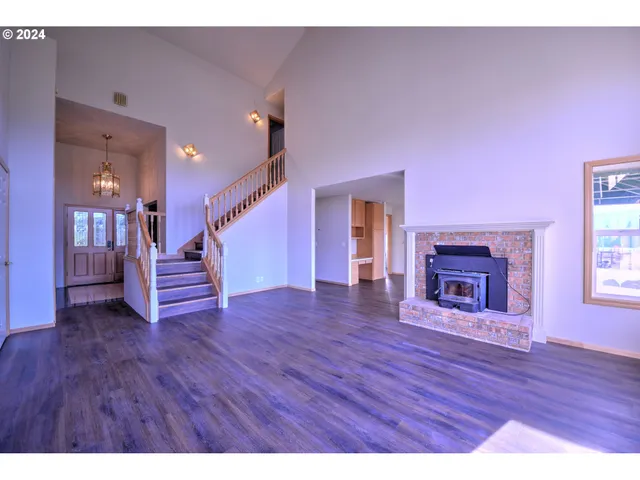 a view of a livingroom with wooden floor and a fireplace