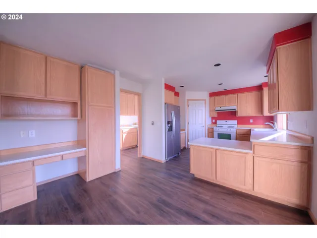 a kitchen with stainless steel appliances a refrigerator and wooden floor