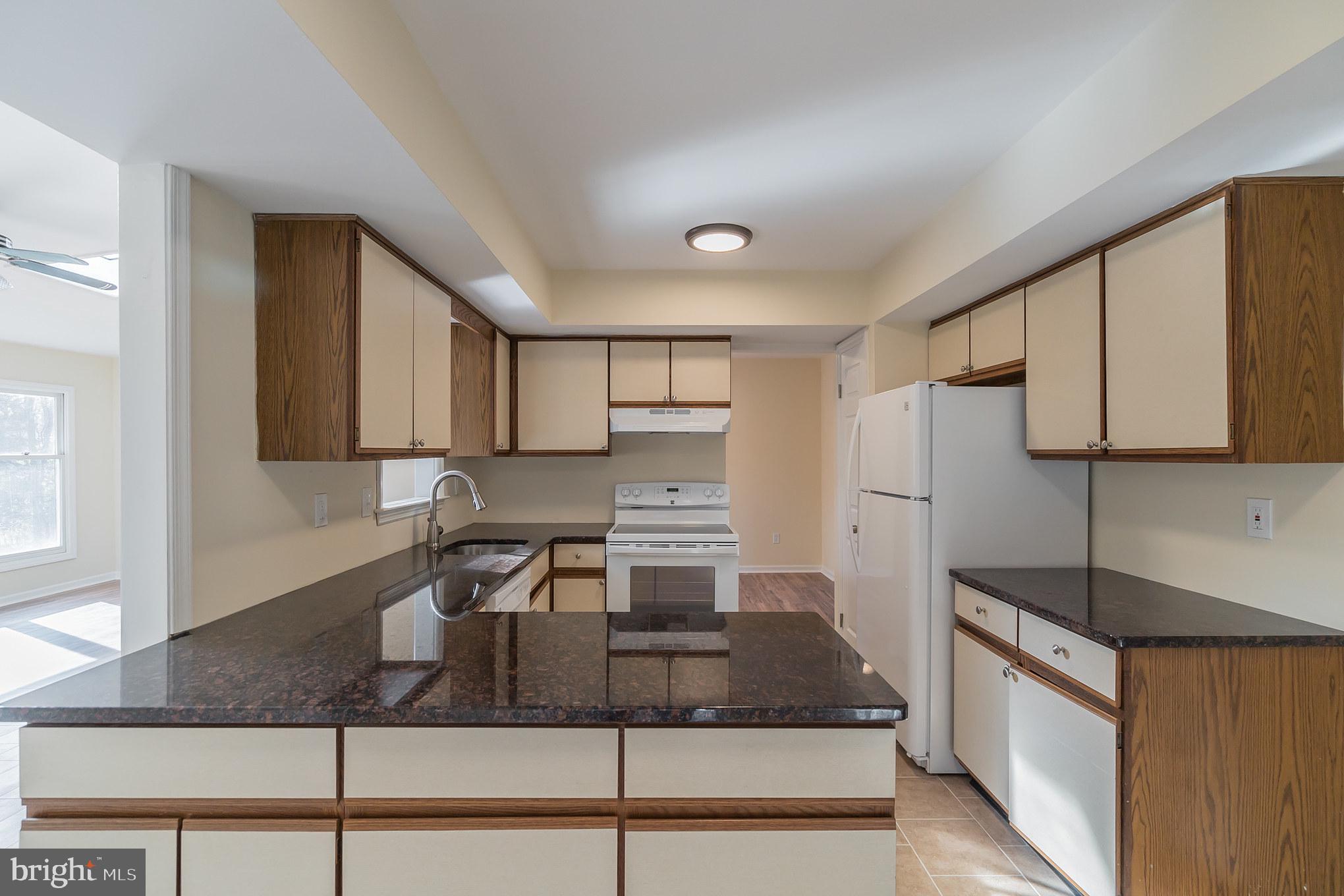 414 Windsor Circle Exton, PA 19341 - Photo 13 of 28 a kitchen with stainless steel appliances granite countertop a sink stove and cabinets