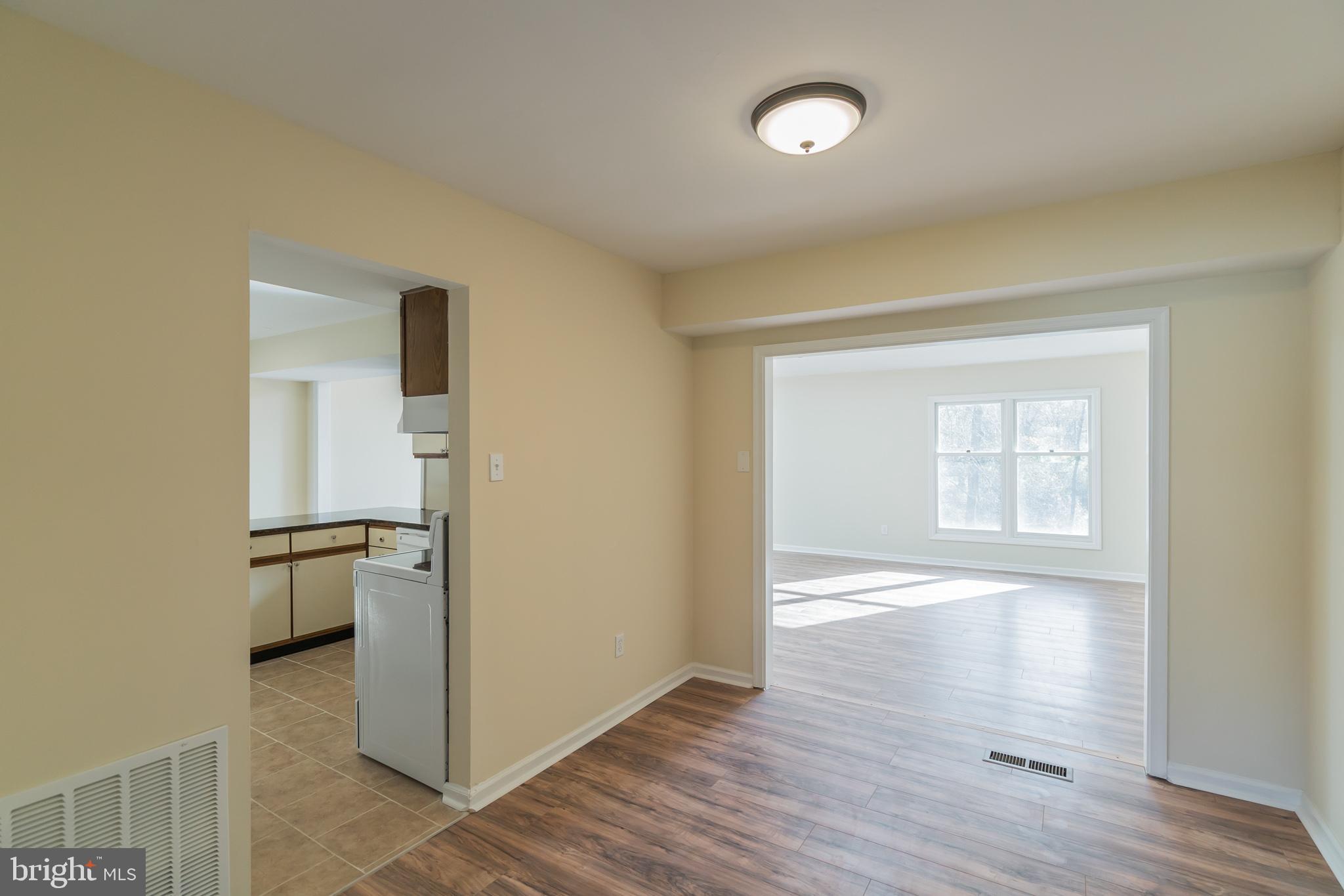 414 Windsor Circle Exton, PA 19341 - Photo 7 of 28 an empty room with wooden floor cabinet and windows