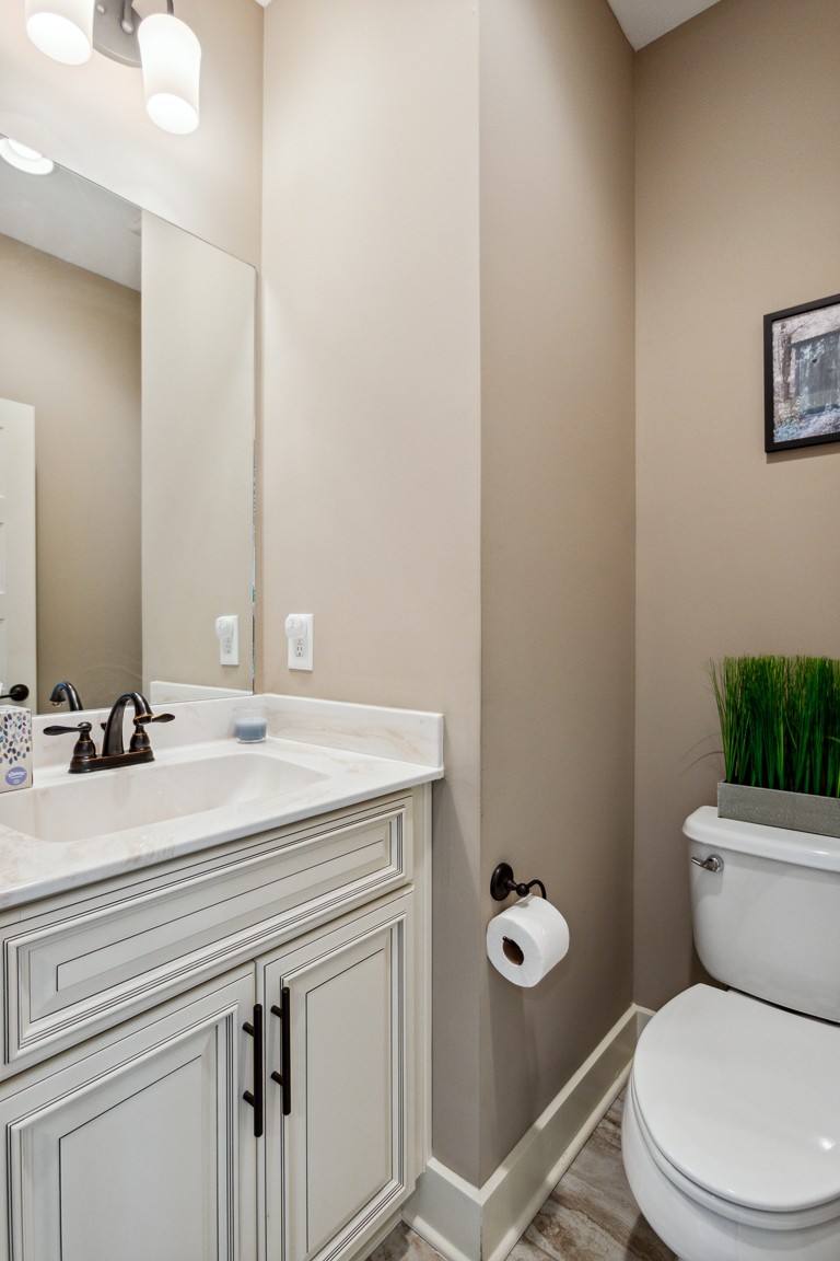 714 Pebble Point Road Lebanon, TN 37087 - Photo 30 of 45 a bathroom with a granite countertop toilet a sink and a mirror