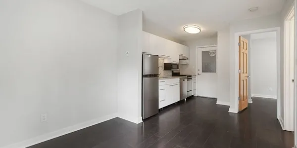 a kitchen with stainless steel appliances a refrigerator and wooden floor
