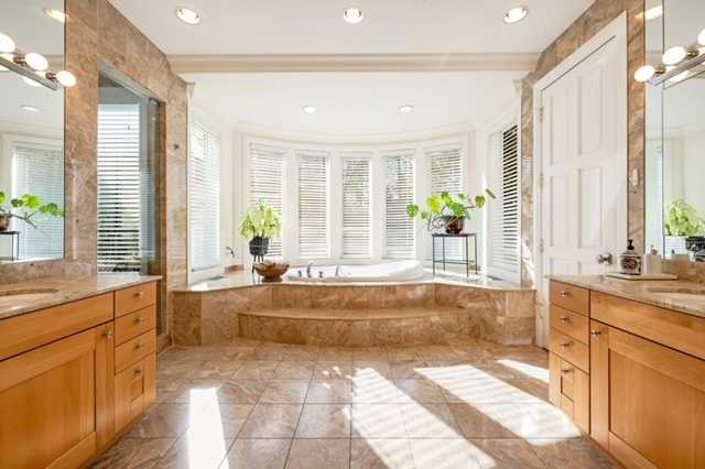 115 Dickens Road Northfield, IL 60093 - Photo 11 of 24 a spacious bathroom with a granite countertop tub next to a large window