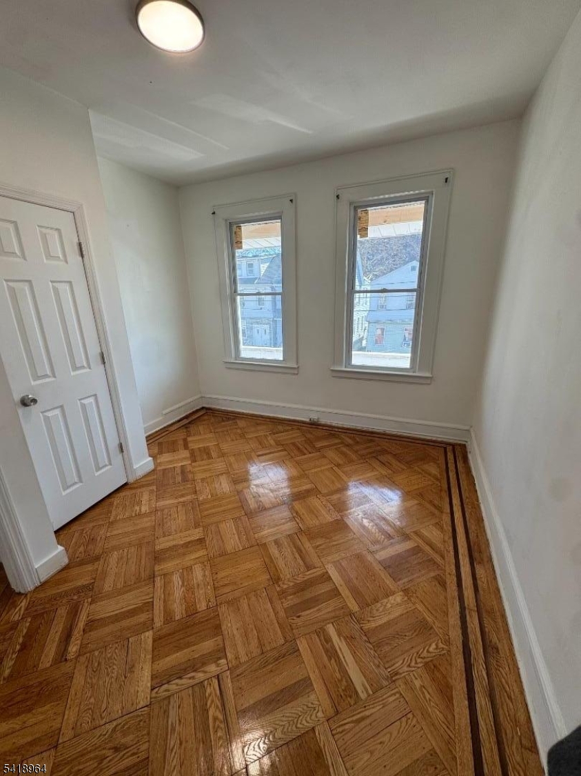 149 Brookside Avenue, Unit 2 Irvington, NJ 07111 - Photo 3 of 8 a view of an empty room with wooden floor and a window