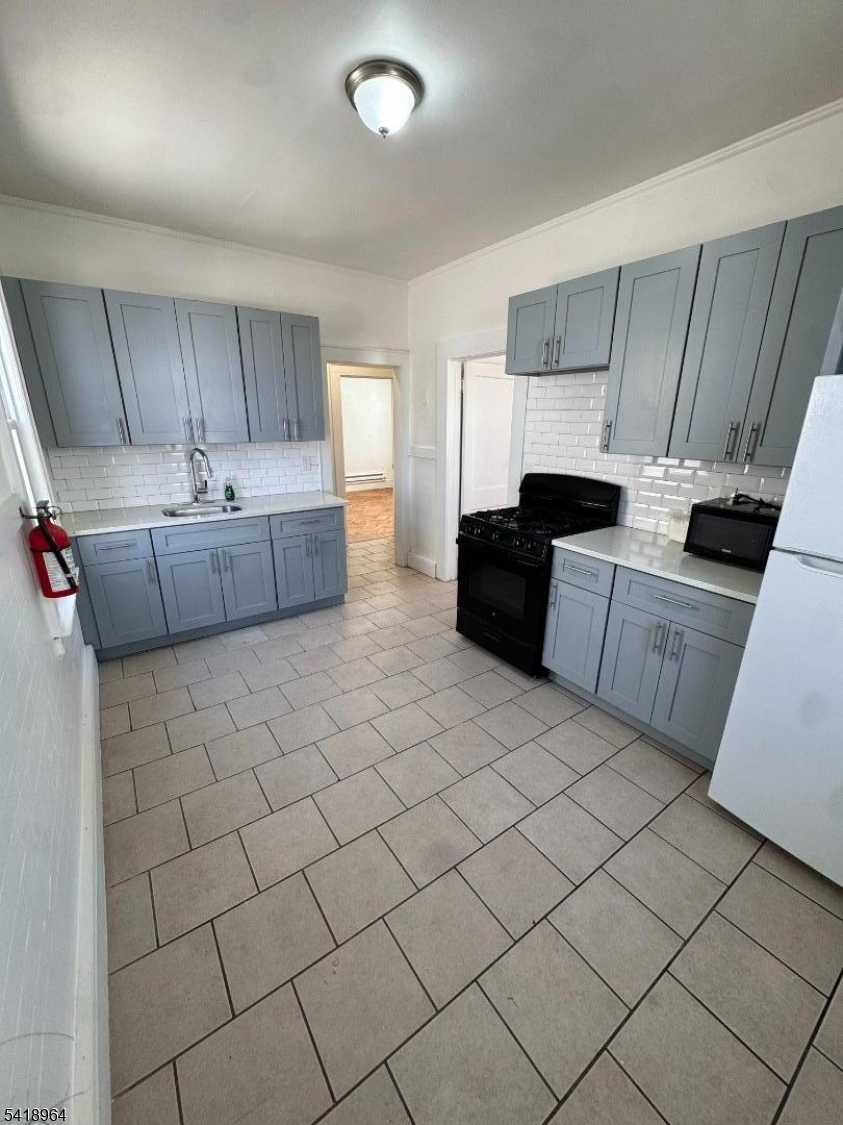 149 Brookside Avenue, Unit 2 Irvington, NJ 07111 - Photo 6 of 8 a large kitchen with a sink and cabinets