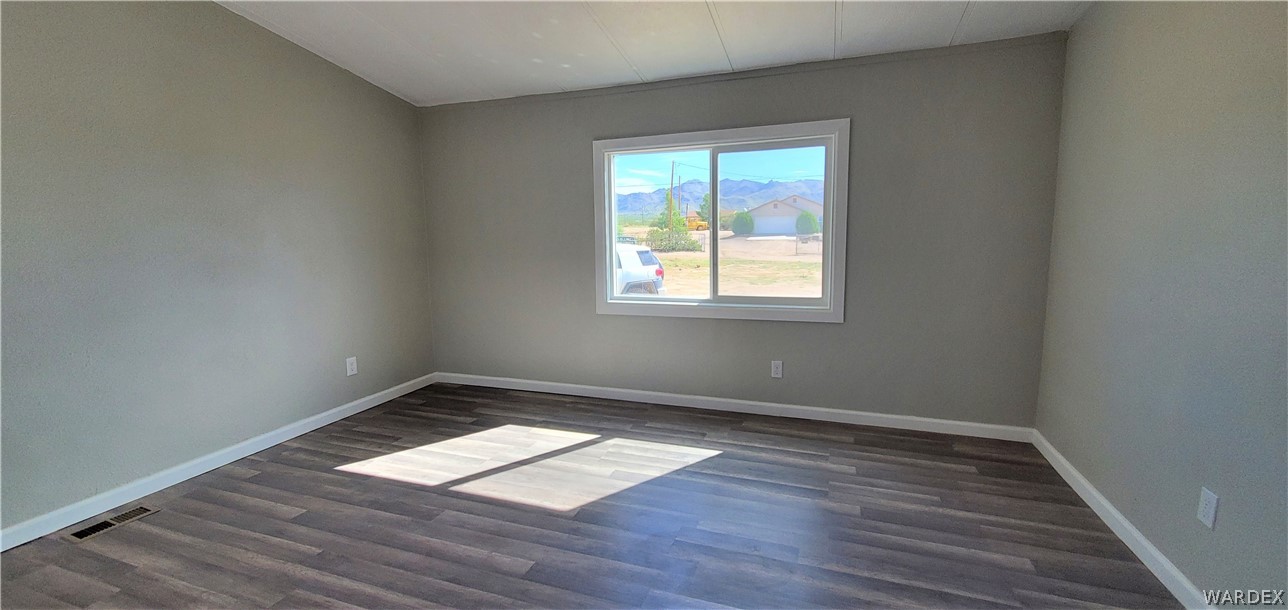 3841 North Avra Road Golden Valley, AZ 86413 - Photo 41 of 78 an empty room with wooden floor and windows
