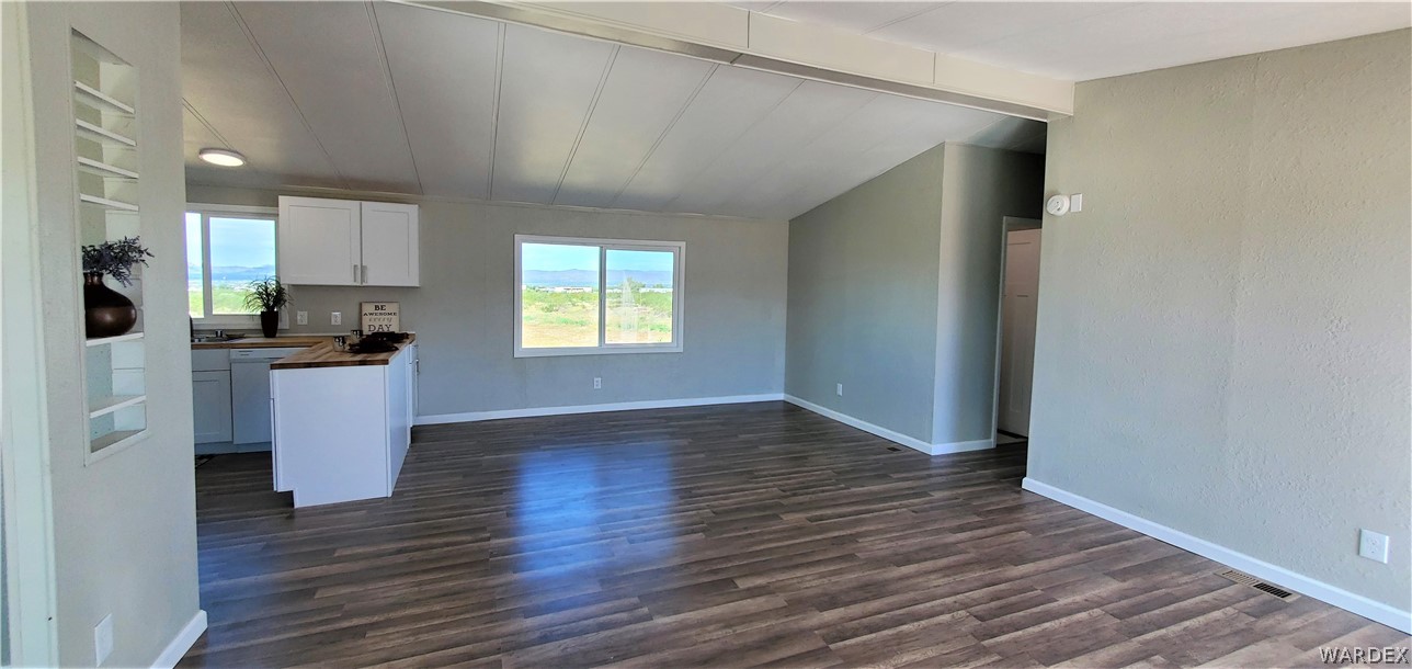 3841 North Avra Road Golden Valley, AZ 86413 - Photo 7 of 78 a view of a kitchen with a sink and dishwasher a refrigerator with wooden floor