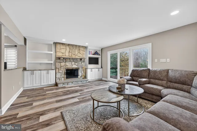 a living room with furniture a large window and a fireplace