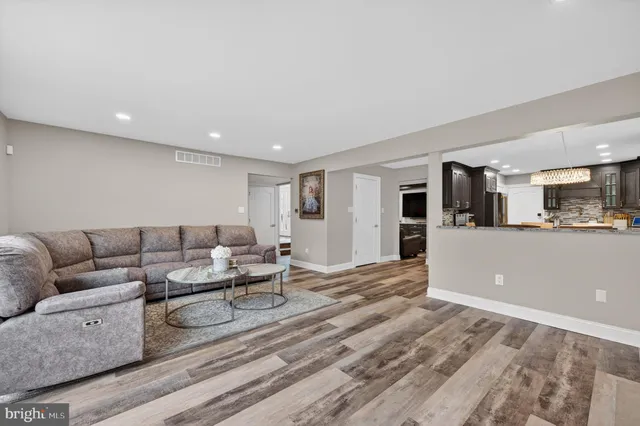 a living room with furniture and view of kitchen