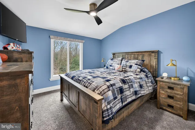 a bedroom with a bed and a flat tv screen on the dresser