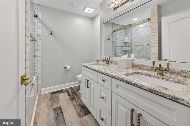 a bathroom with a granite countertop sink toilet and shower