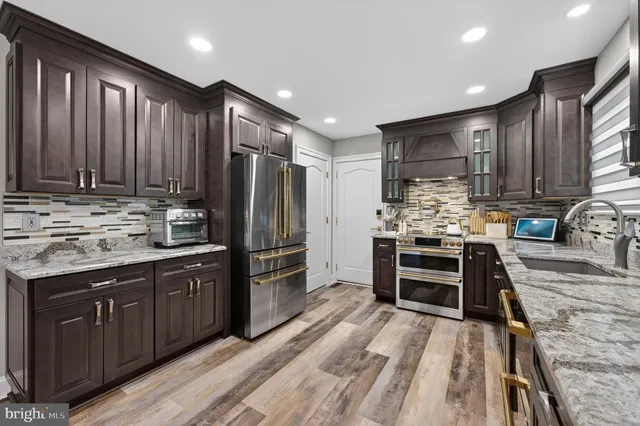 a kitchen with kitchen island granite countertop wooden cabinets and stainless steel appliances