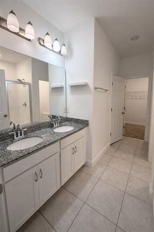 2237 Shadowland Loop Winter Park, FL 32792 - Photo 12 of 20 a spacious bathroom with a granite countertop sink a mirror and a shower