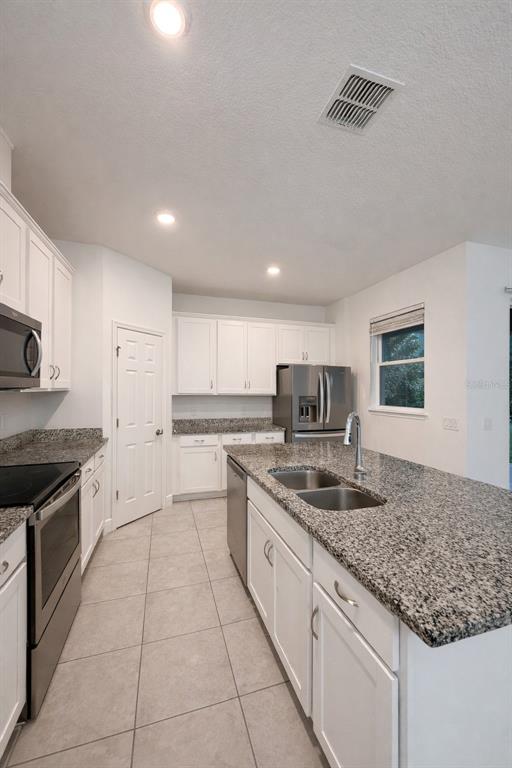 2237 Shadowland Loop Winter Park, FL 32792 - Photo 4 of 20 a kitchen with stainless steel appliances granite countertop a sink stove and cabinets