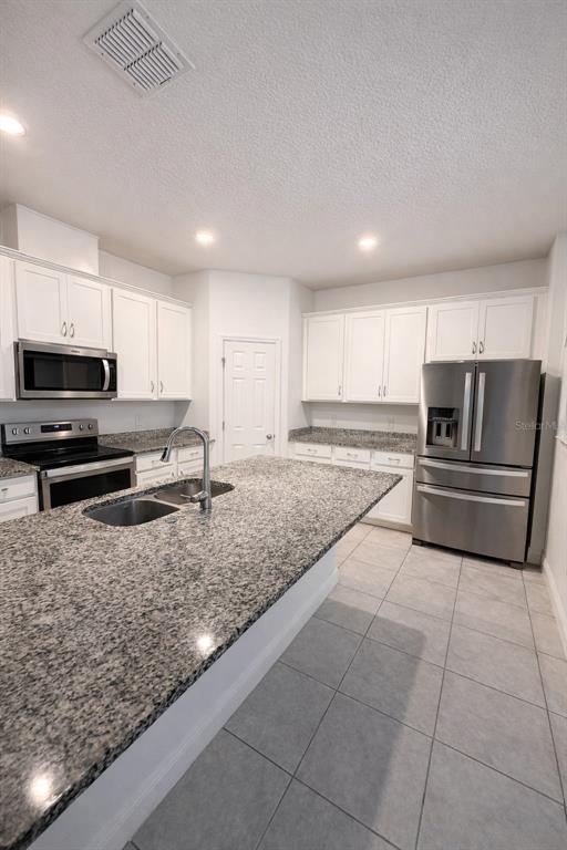 2237 Shadowland Loop Winter Park, FL 32792 - Photo 5 of 20 a kitchen with stainless steel appliances granite countertop a sink refrigerator and microwave