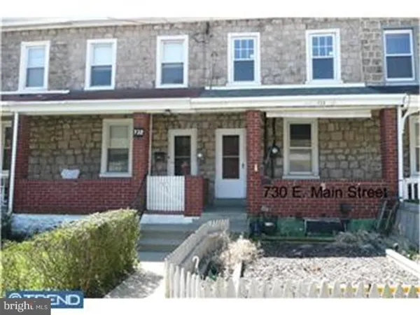 a front view of a house with a yard and outdoor seating