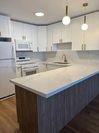 a kitchen with kitchen island a sink stainless steel appliances and cabinets