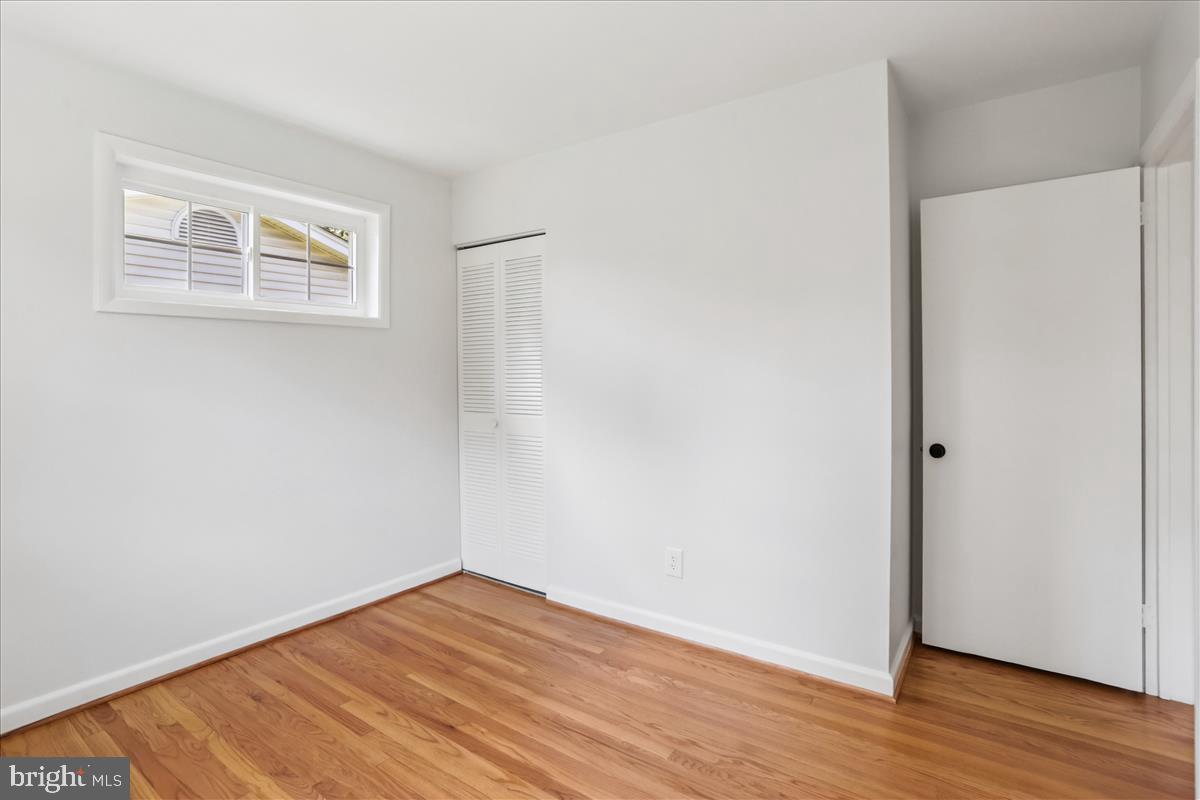 406 Waterford Road Silver Spring, MD 20901 - Photo 19 of 42 a view of an empty room with wooden floor and a window