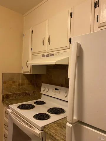 a white stove top oven sitting inside of a kitchen