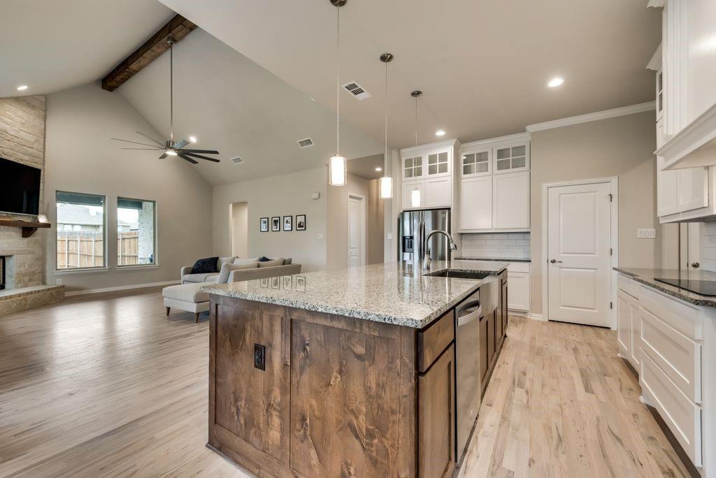 125 Katalina Lane Waxahachie, TX 75165 - Photo 14 of 34 a kitchen with counter top space a sink wooden floor and stainless steel appliances