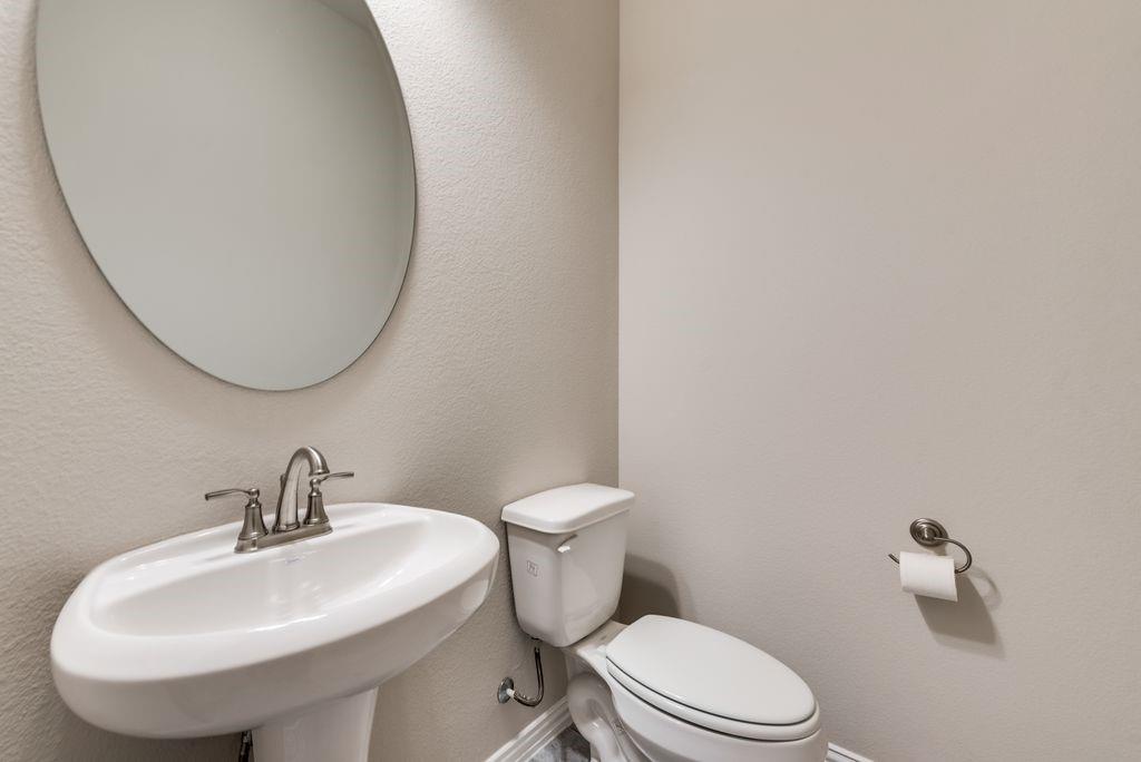 125 Katalina Lane Waxahachie, TX 75165 - Photo 18 of 34 a white toilet sitting next to a bathroom sink