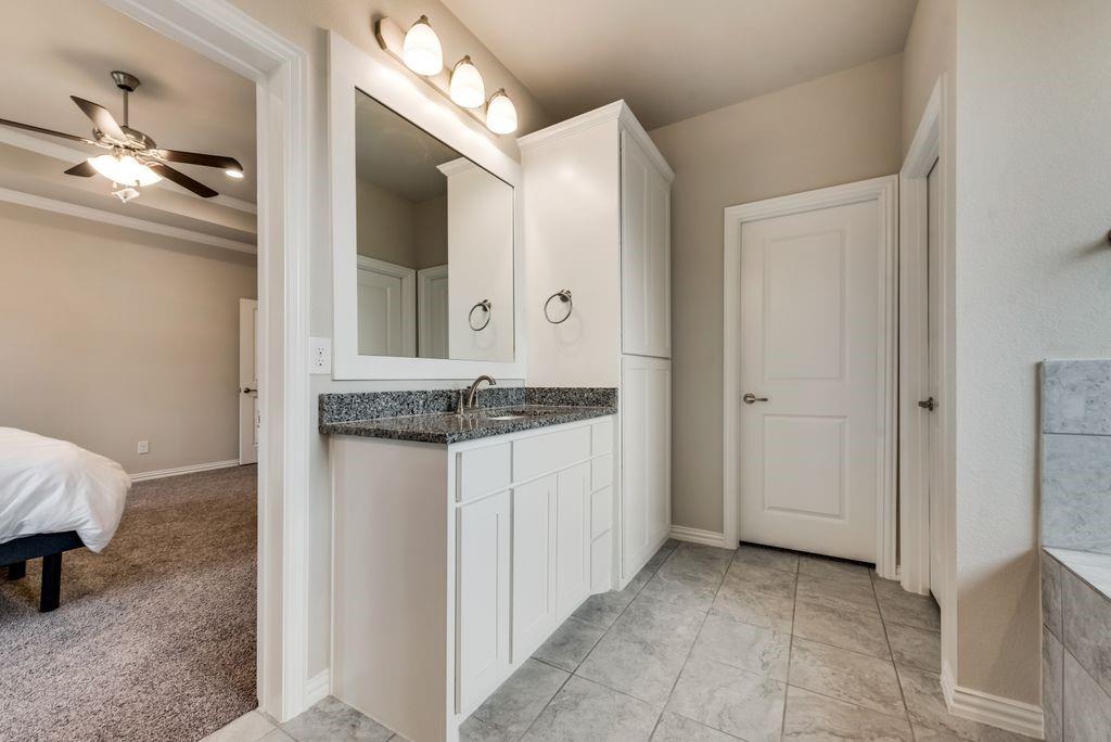 125 Katalina Lane Waxahachie, TX 75165 - Photo 24 of 34 a bathroom with a granite countertop sink and a mirror