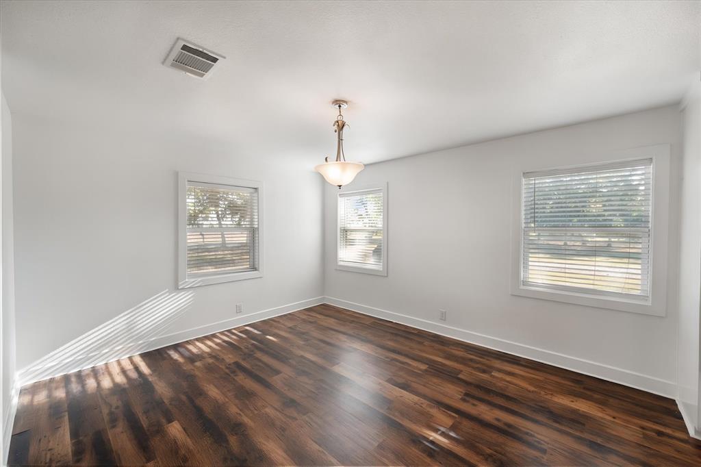 917 Goodwyn Road Italy, TX 76651 - Photo 14 of 40 Wood-finish flooring, white walls, and multiple windows with blinds