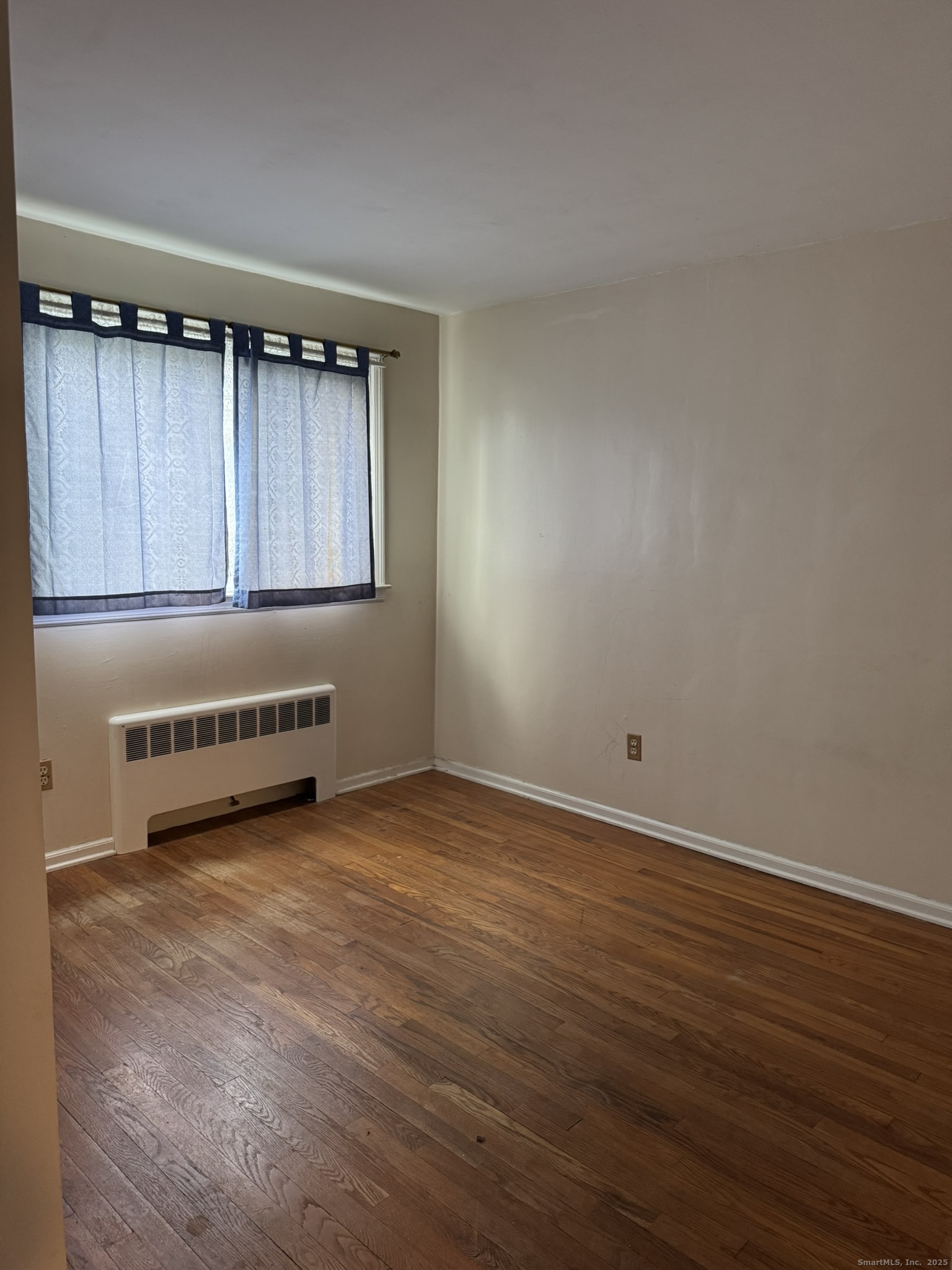 111 Harvard Street Hartford, CT 06106 - Photo 7 of 21 a view of an empty room with wooden floor and a window