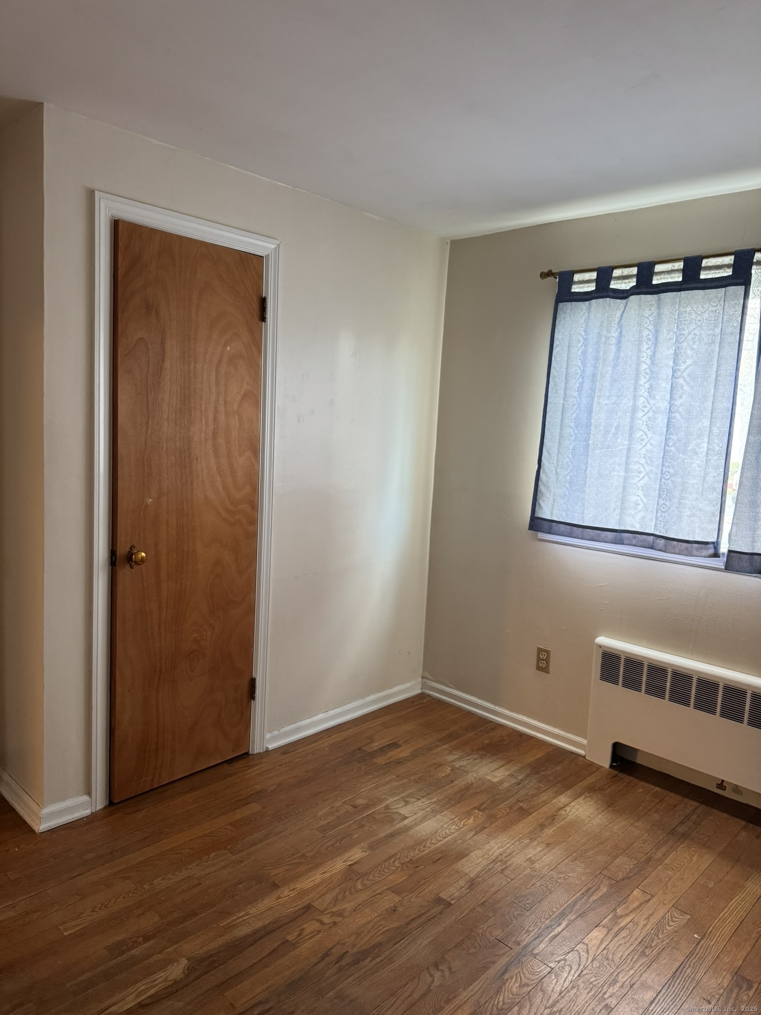 111 Harvard Street Hartford, CT 06106 - Photo 8 of 21 a view of an empty room with wooden floor and a window