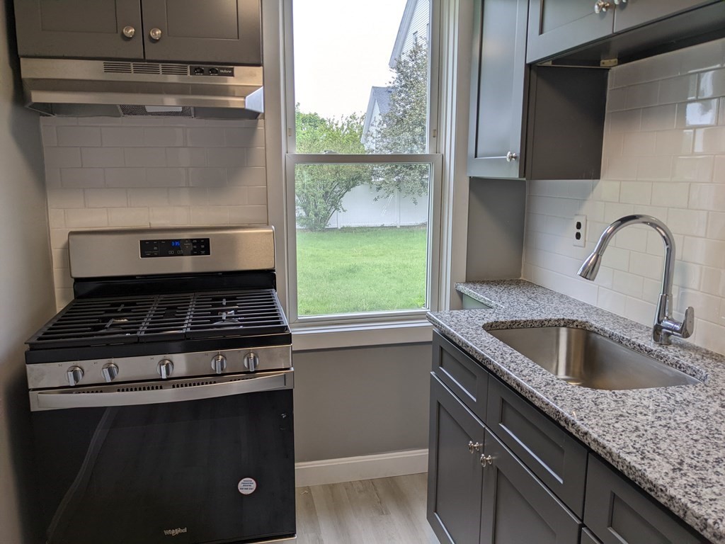 447 Warren Street Fall River, MA 02721 - Photo 4 of 20 a kitchen with a stove and a sink