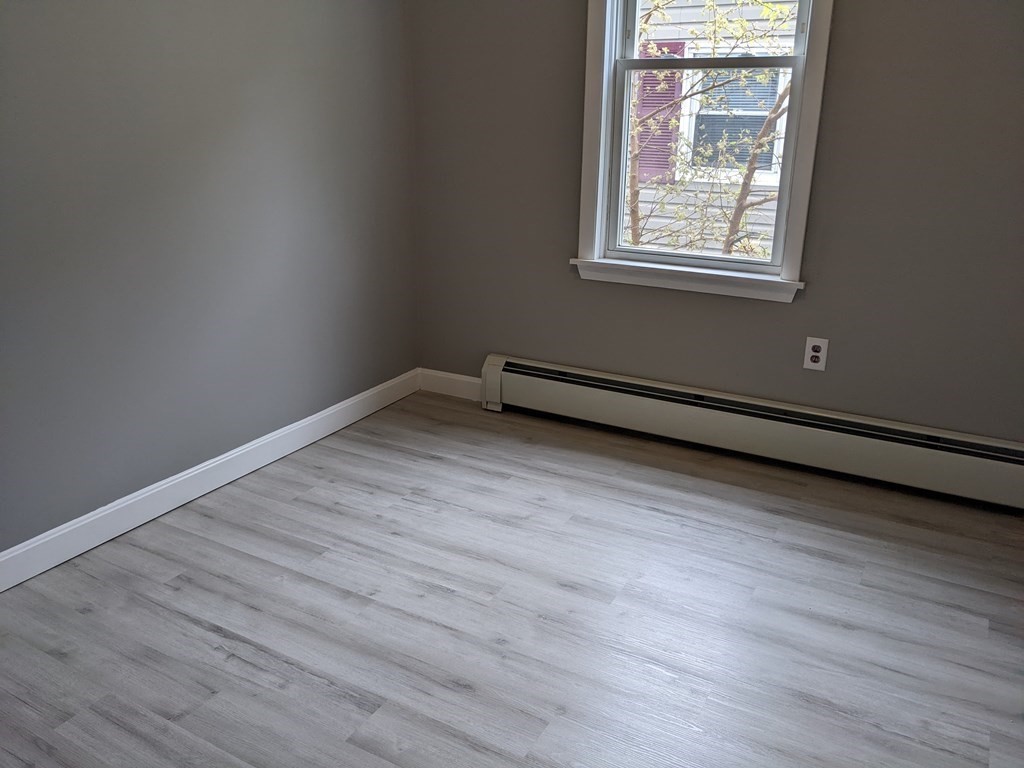447 Warren Street Fall River, MA 02721 - Photo 10 of 20 an empty room with wooden floor and windows