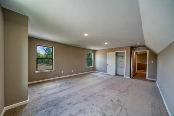 an empty room with windows and closet