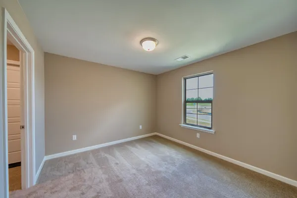 an empty room with windows and closet