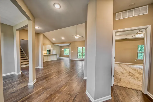 a view of a hallway with wooden floor and a living room