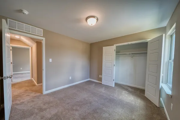 an empty room with closet and a fireplace