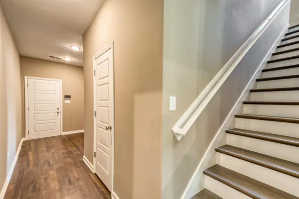 a view of a hallway with wooden floor and entryway