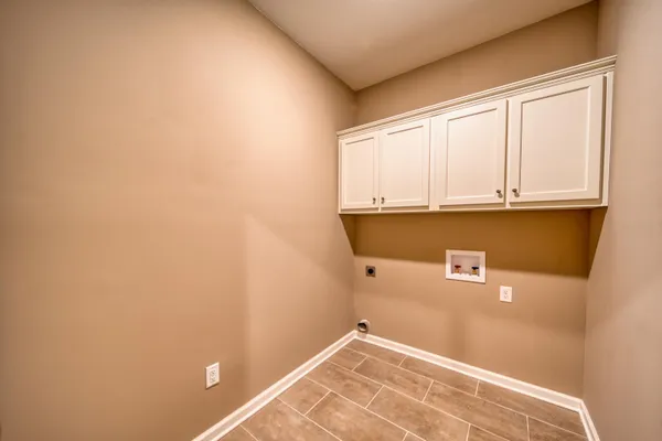 a view of a kitchen with white cabinets and a window