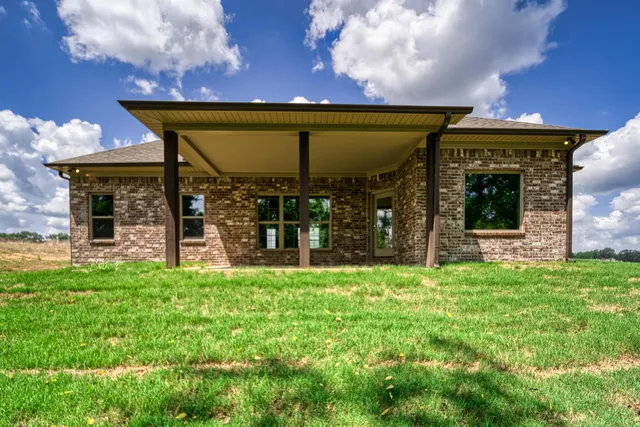 a view of a house with a porch and a yard