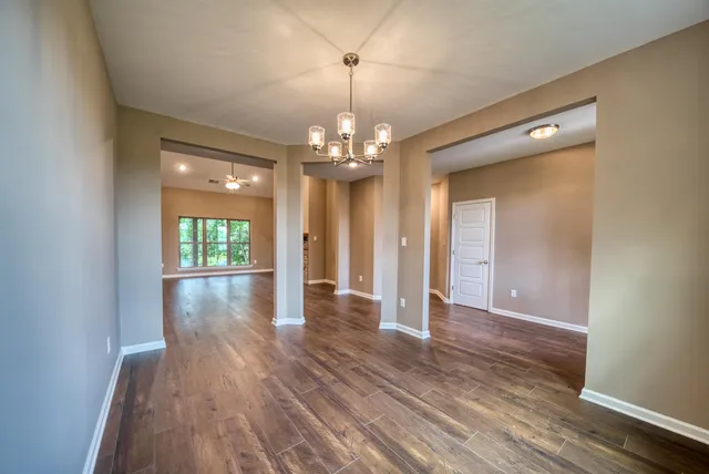 a view of a livingroom with wooden floor and chandelier