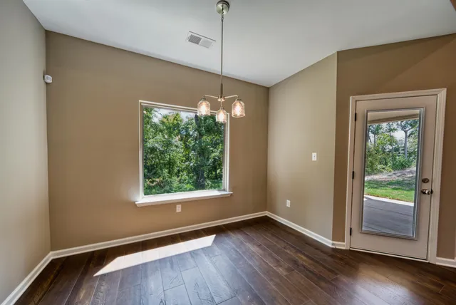 a view of a room with wooden floor and window