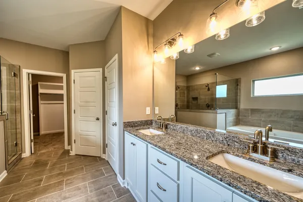 a bathroom with a granite countertop sink a mirror and a shower