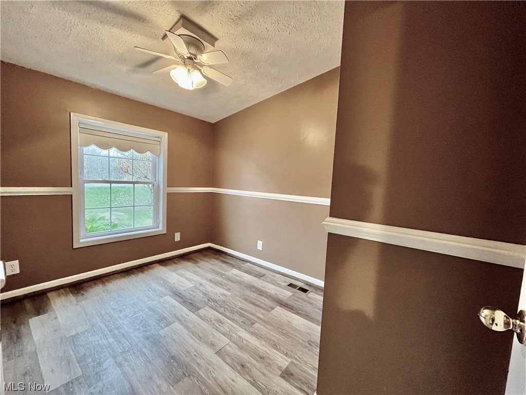 4214 School House Road Little Hocking, OH 45742 - Photo 10 of 29 Spare room featuring light hardwood / wood-style floors, ceiling fan, and a textured ceiling