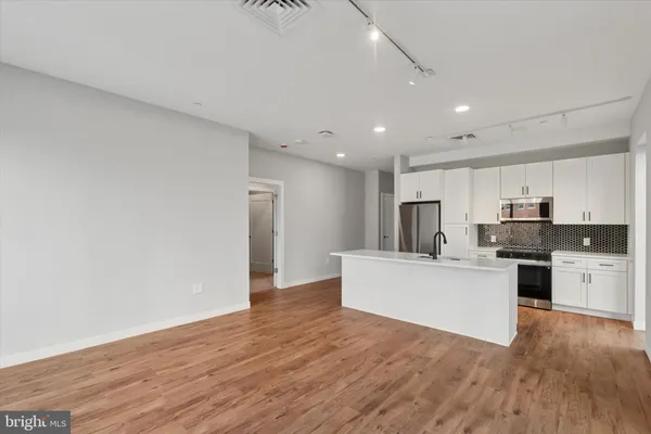 a view of kitchen with microwave a stove top oven and white cabinets