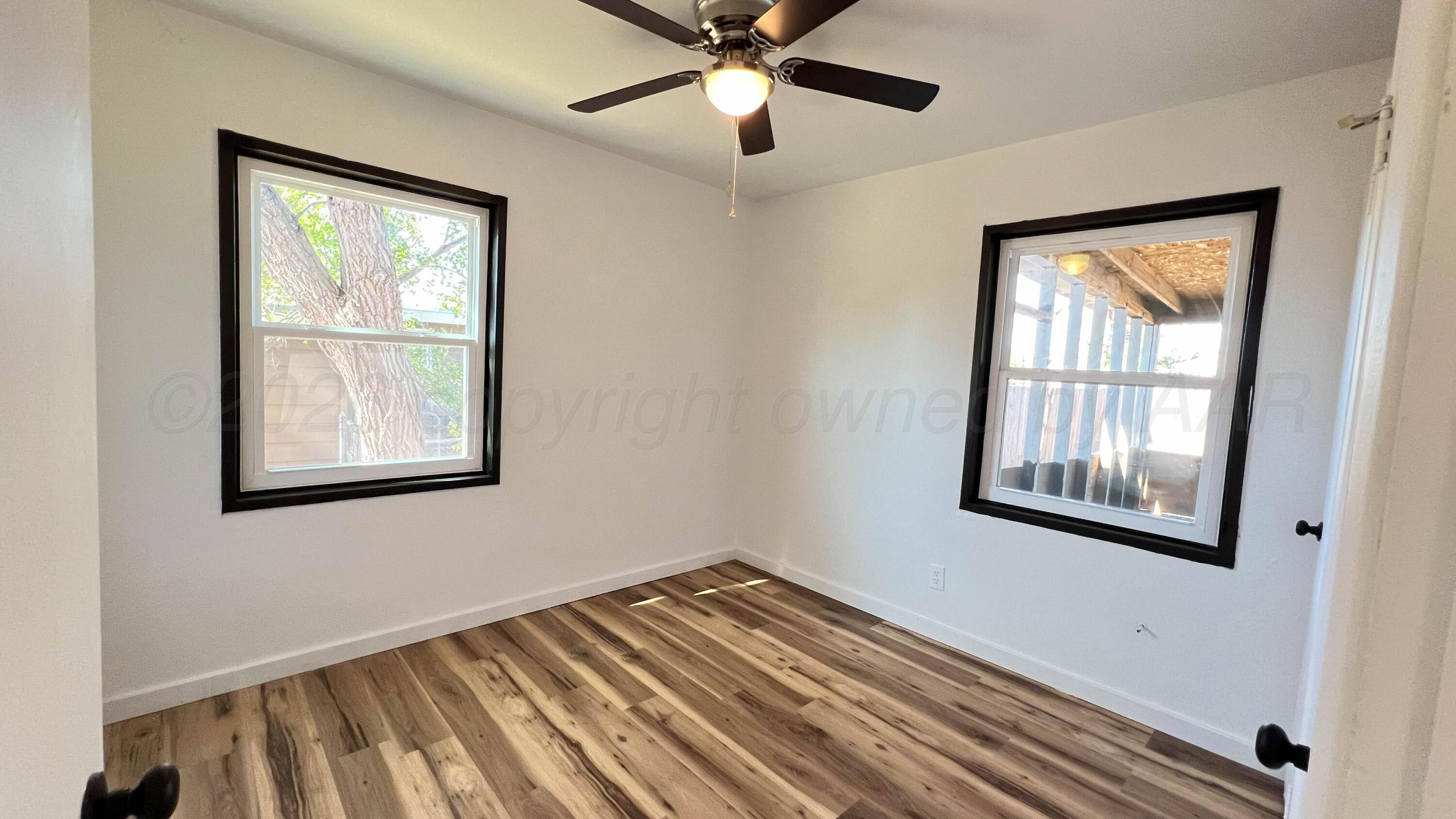 4410 South Ong Street Amarillo, TX 79110 - Photo 11 of 22 a view of an empty room with a window and wooden floor