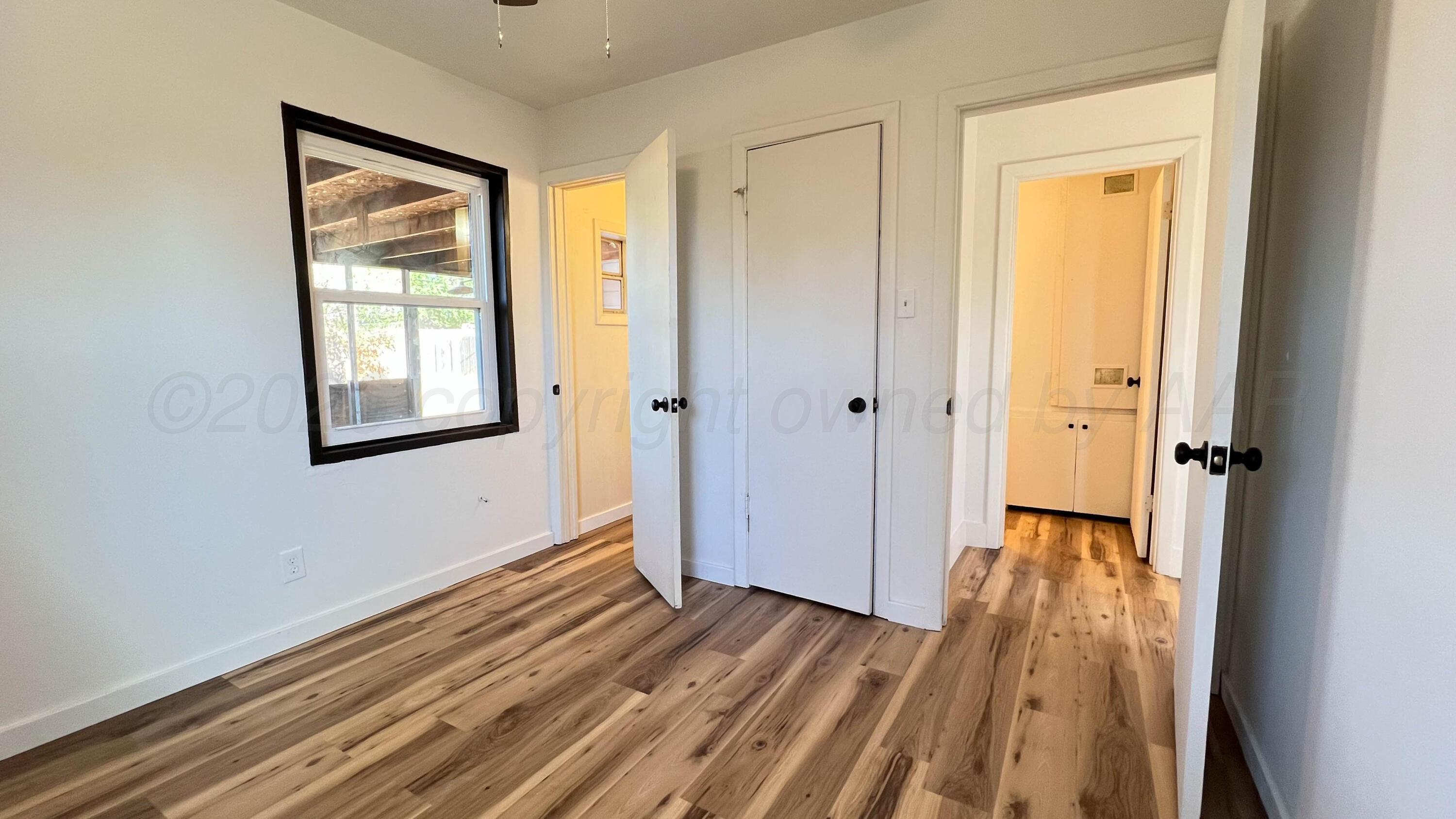 4410 South Ong Street Amarillo, TX 79110 - Photo 12 of 22 a view of a hallway with wooden floor and a bathroom