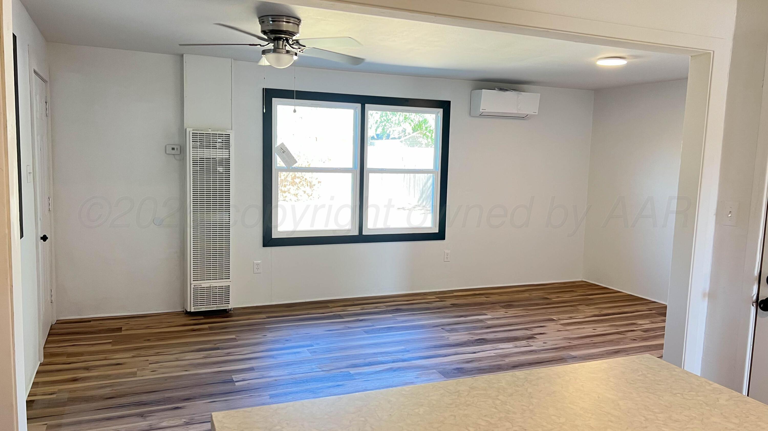 4410 South Ong Street Amarillo, TX 79110 - Photo 4 of 22 a view of an empty room with wooden floor and a window