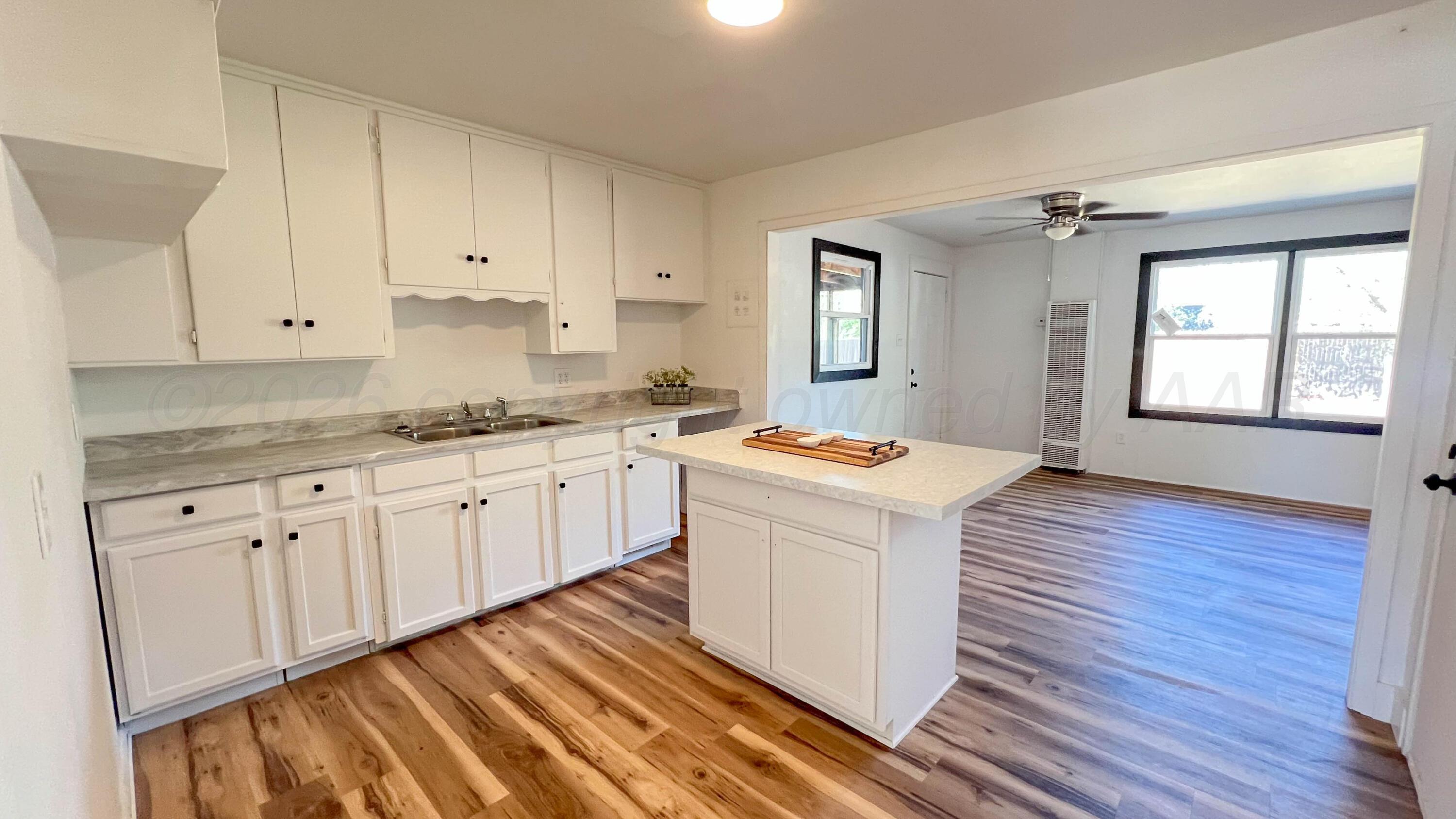 4410 South Ong Street Amarillo, TX 79110 - Photo 5 of 22 a kitchen with granite countertop white cabinets and white appliances